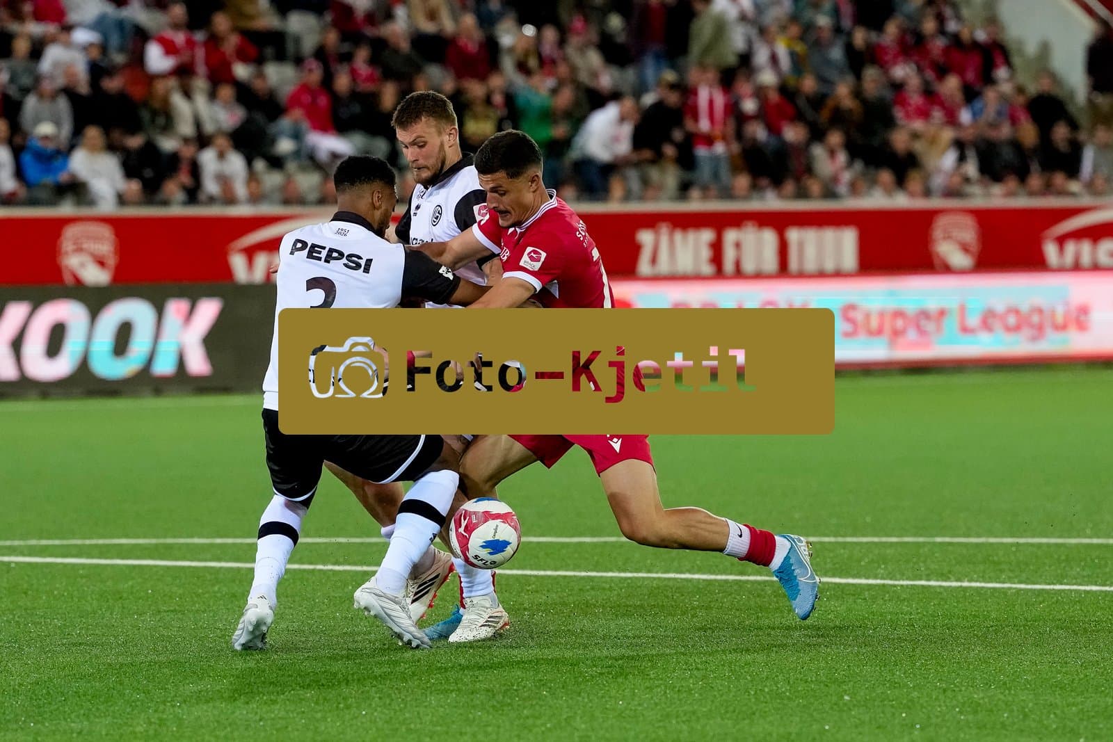 Schweiz: Super League 2025 - 2026, FC Thun vs FC Lugano - Stockhorn Arena, Thun: Elmin Rastoder (74 Thun) gegen Lukas Mai (17 FC Lugano) und Hannes Delcroix (3 FC Lugano)